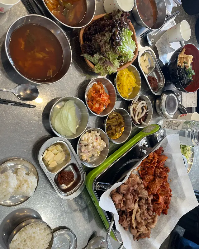 불고기와 쌈 채소, 다양한 밑반찬들이 테이블 가득 놓여있다.