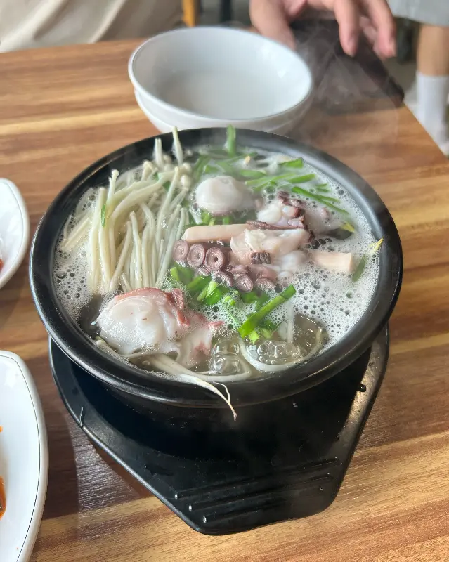 뽀얀 국물에 문어, 숙주, 버섯 등이 들어간 문어국밥