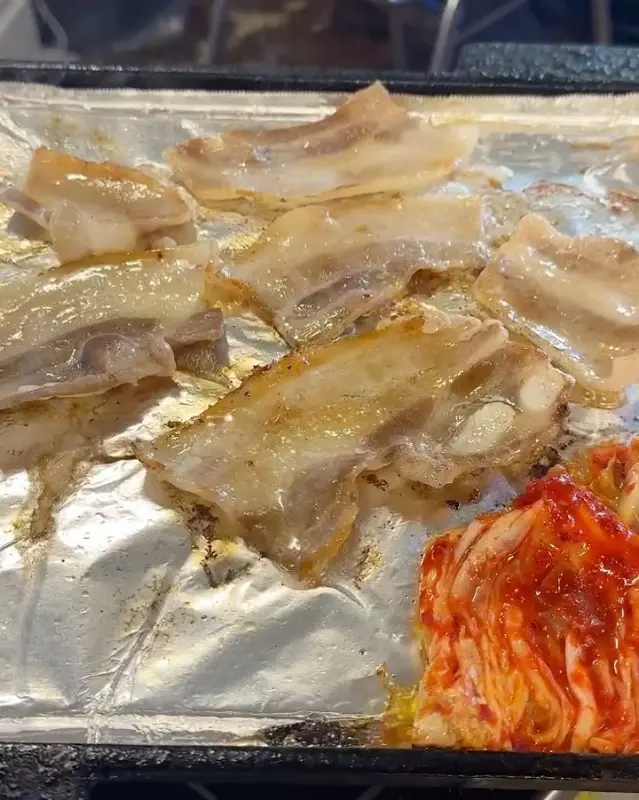 잘 구워진 냉동 삼겹살과 김치