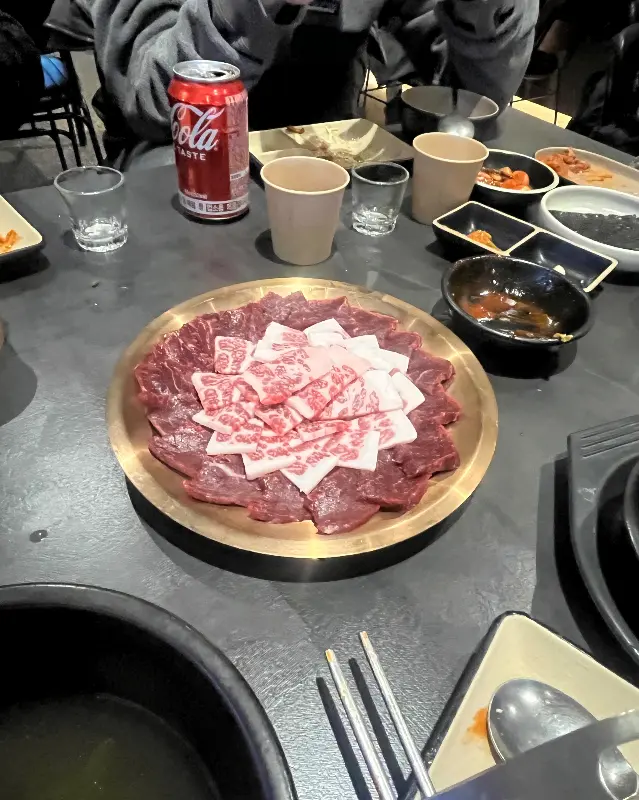 뭉티기와 함께 다양한 밑반찬이 차려진 테이블 전경