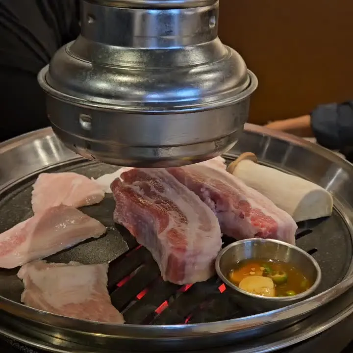 전문가의 손길로 구워지는 두툼한 삼겹살