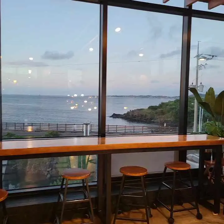 통유리창 너머로 보이는 푸른 바다와 성산일출봉