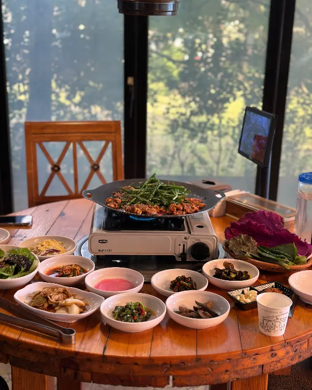 테이블 가득 차려진 밑반찬과 오리 주물럭