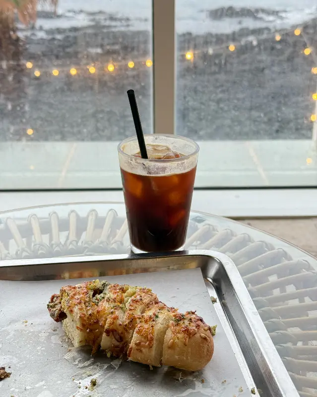 창밖으로 보이는 바다와 음료, 빵