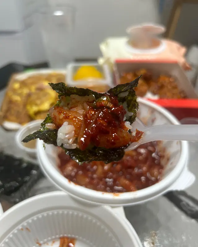 김에 밥과 새우무침을 함께 싸 먹는 모습