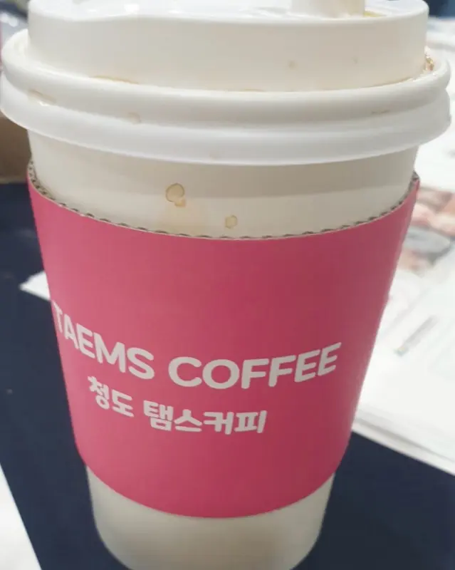 탬스커피 슬리브를 착용한 테이크아웃 컵