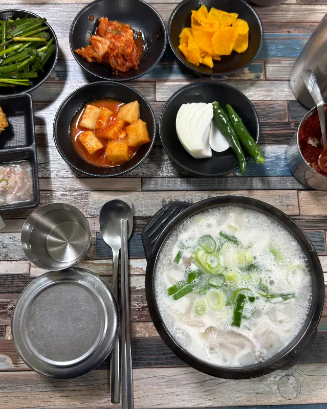 테이블 위에 가득 차려진 밑반찬과 국밥