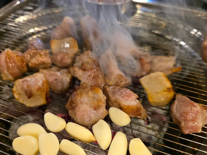 숯불 위에서 구워지는 꼬들목살과 삼겹살