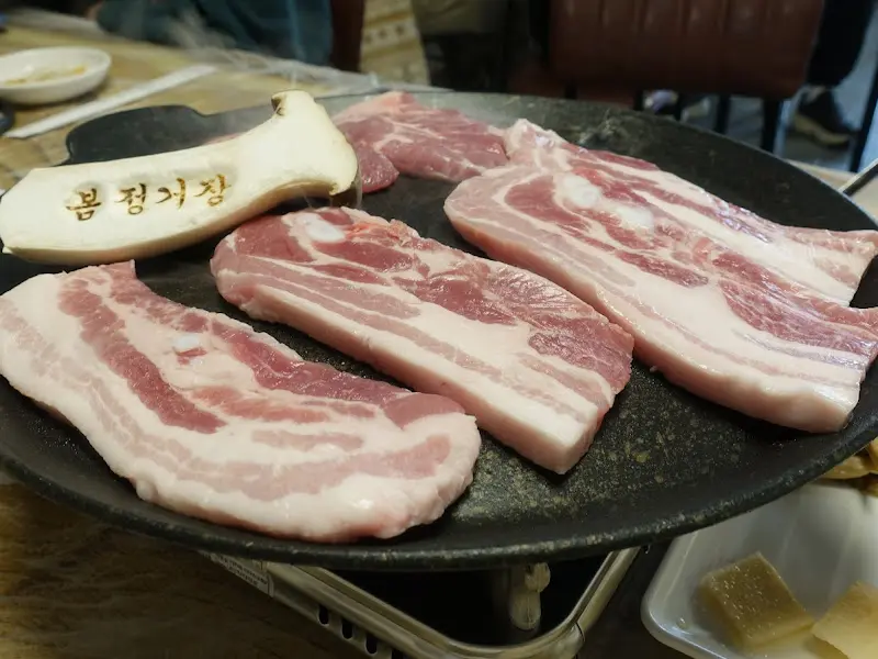 불판 위의 삼겹살과 미나리