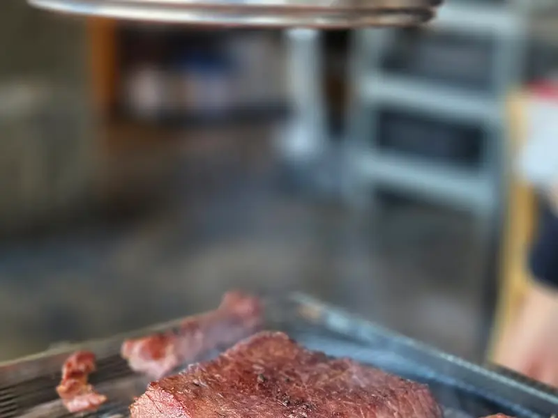 숯불 위에서 구워지는 두툼한 고기