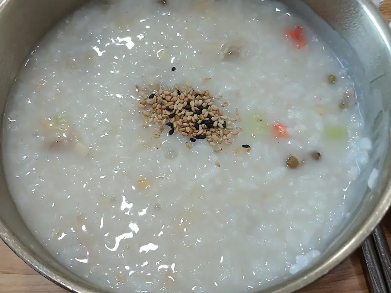 고소한 깨가 뿌려진 따뜻한 바지락죽