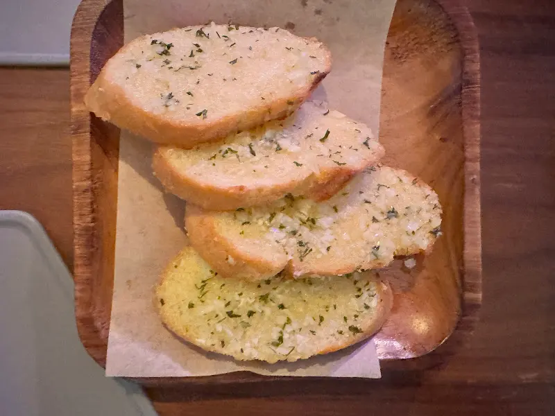 나무 접시에 담긴 마늘빵