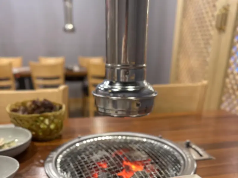 테이블 중앙에 놓인 숯불 구이 시설