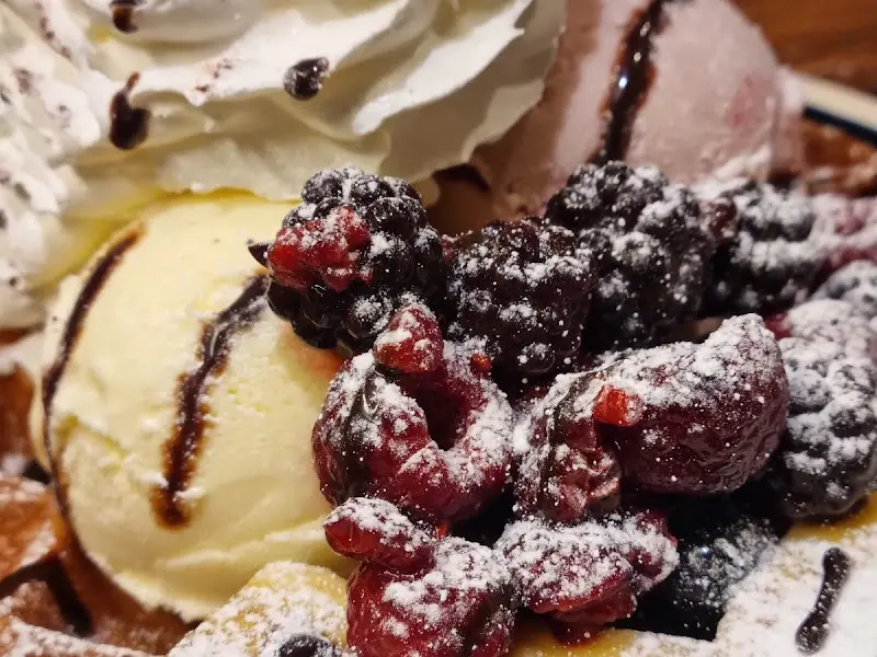 와플 위에 올려진 아이스크림과 라즈베리