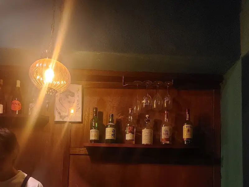 어둑한 조명 아래 술병들이 진열된 모습