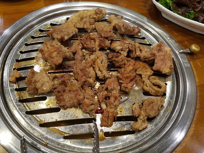 잘 구워진 돼지갈비 조각들이 석쇠 위에 가지런히 놓여 있다. 윤기가 흐르고, 숯불 향이 느껴지는 듯하다.