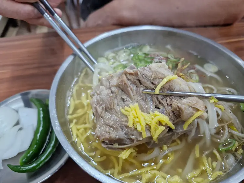 살코기가 듬뿍 붙은 뼈를 들어올린 모습