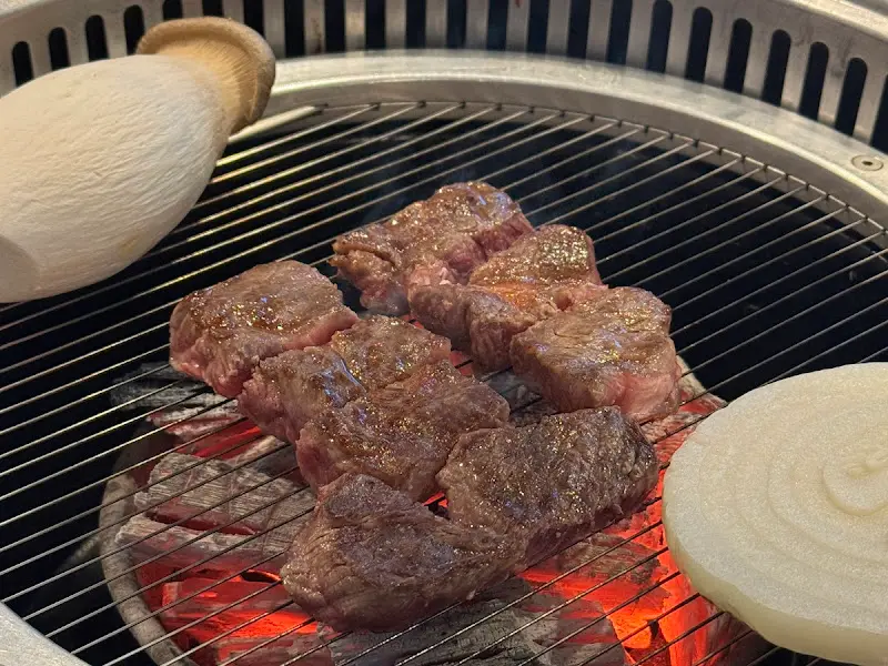 숯불 위에서 익어가는 깍둑썰기된 한우.