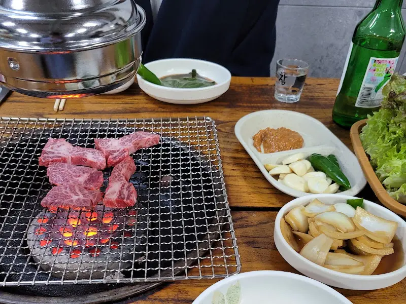 연탄불 위에서 지글거리는 갈비살과 밑반찬들