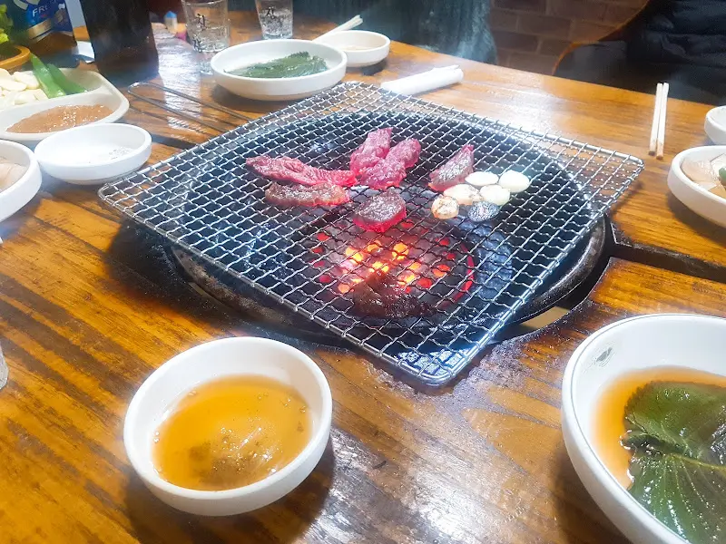 연탄불 위에서 갈비살과 마늘이 함께 익어가는 모습