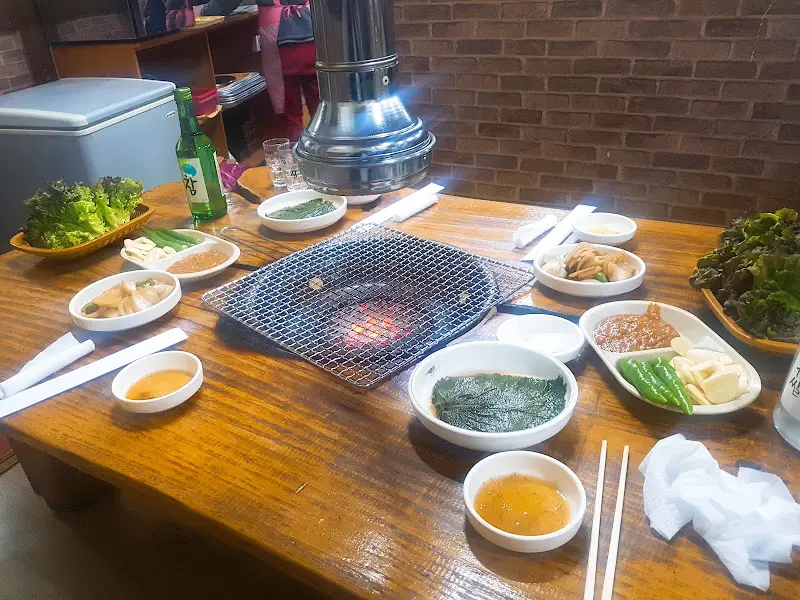 테이블 가득 차려진 밑반찬과 갈비살