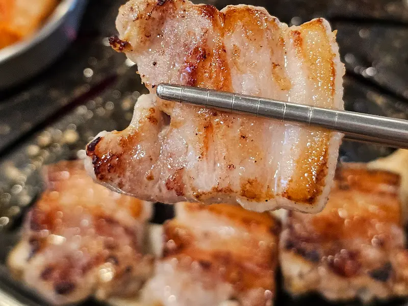 젓가락으로 집은 삼겹살