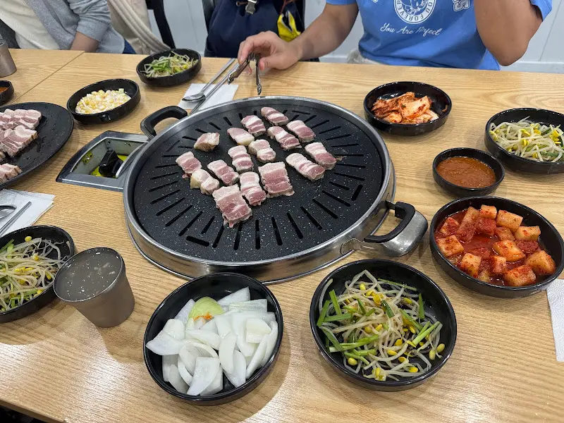 다양한 반찬과 구워지고 있는 고기