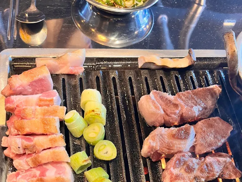 숯불 위에서 맛있게 익어가는 고기와 채소