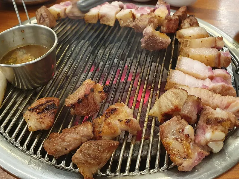 숯불 위에서 익어가는 다양한 부위의 흑돼지