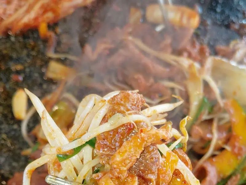 오리고기와 콩나물, 부추를 함께 집어 올린 모습