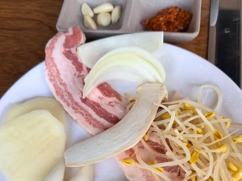 삼겹살과 곁들임 채소가 담긴 접시