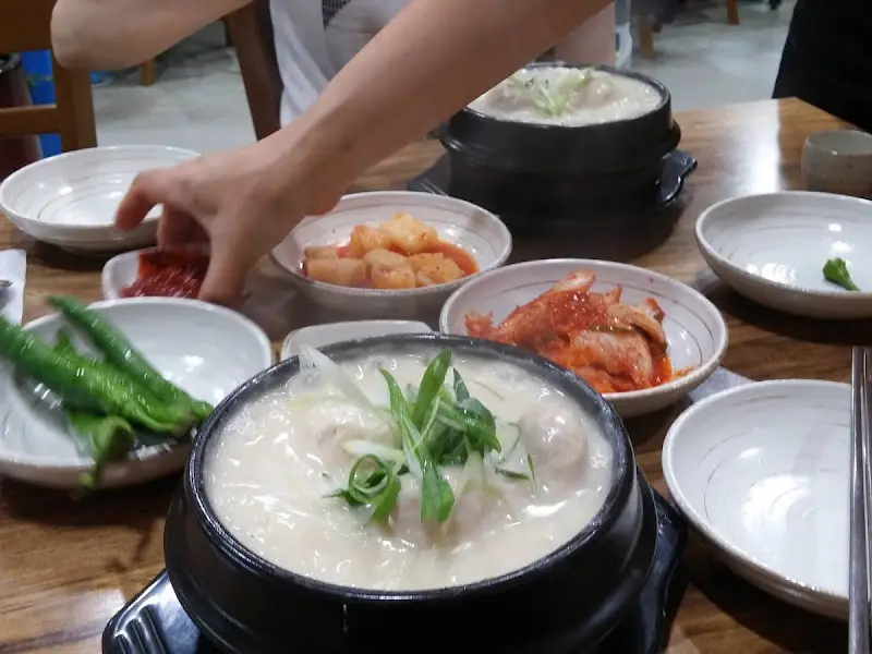 테이블 위에 놓인 삼계탕과 다양한 밑반찬