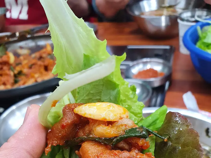 싱싱한 채소에 돼지고기와 마늘을 얹어 한 입 가득