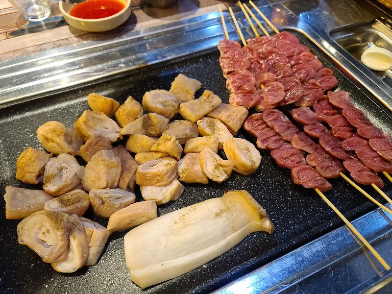 막창과 곱창이 구워지기 전 불판 위에 놓여 있는 모습