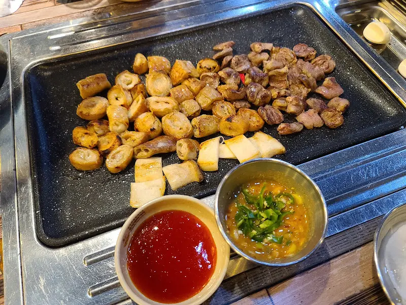 맛있게 구워진 곱창과 막창을 소스에 찍어 먹는 모습