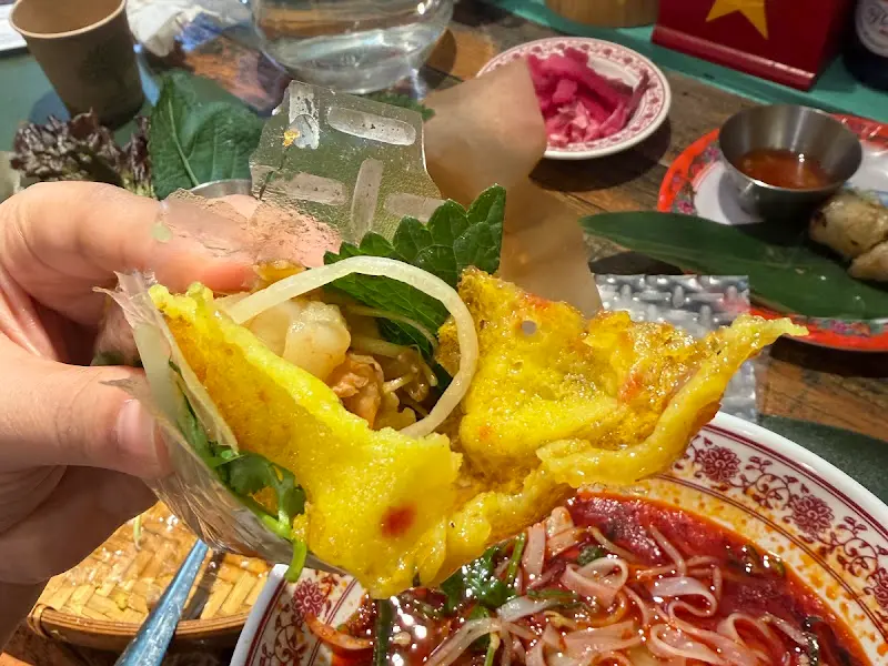 반쎄오를 라이스페이퍼에 싸서 먹는 모습