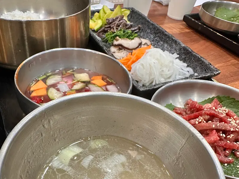 육회와 신선한 채소가 놋그릇에 담겨 나온 육회비빔밥