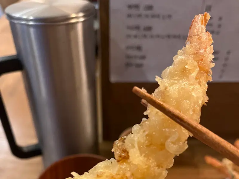 젓가락으로 집어올린 새우튀김