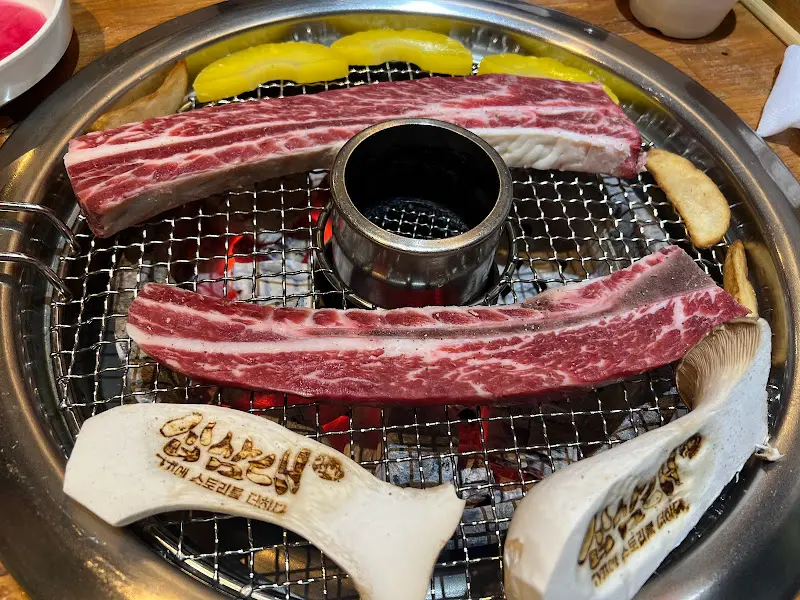 숯불 위에서 익어가는 우대갈비와 버섯