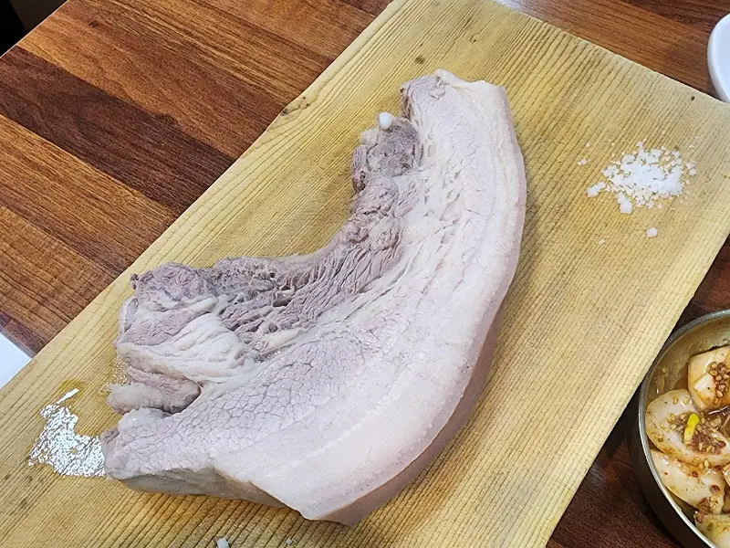 도마 위에 놓인 흑돼지 돔베고기 한 덩이