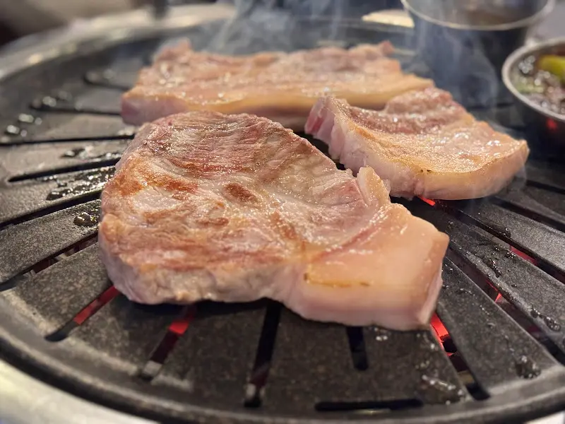 숯불 위에서 지글지글 익어가는 흑돼지 오겹살