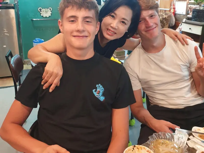 밝은 표정으로 사진을 찍은 손님과 사장님의 모습