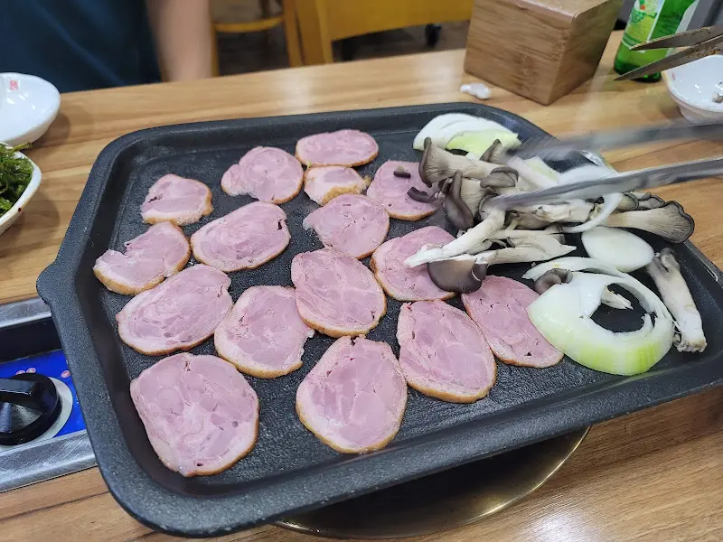 훈제오리와 양파, 버섯이 함께 구워지는 모습