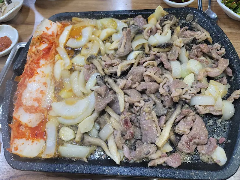 오리 주물럭과 양파, 김치의 조화로운 모습