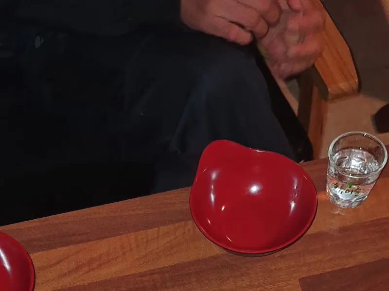 테이블 위에 놓인 붉은색 앞접시와 물잔