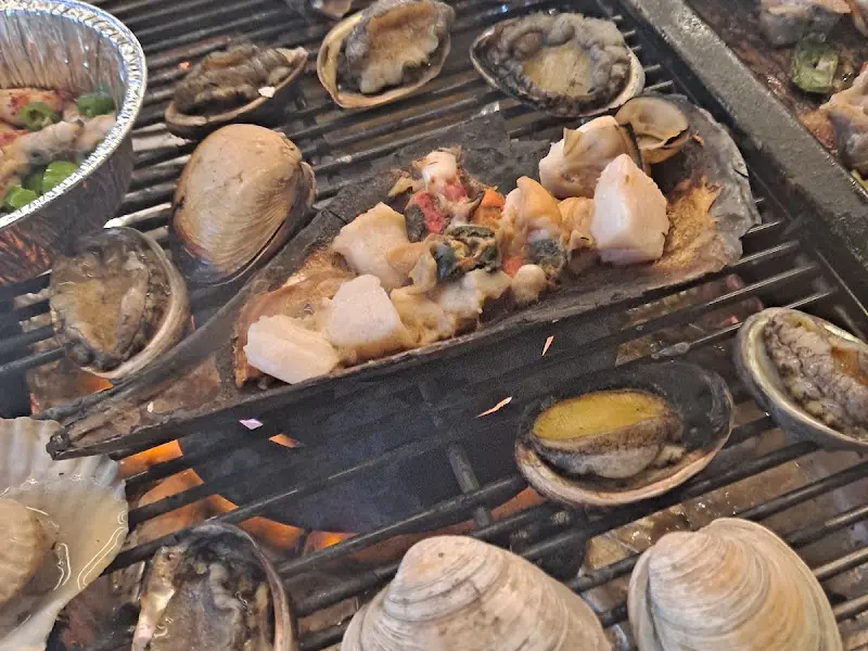 키조개 위에 다양한 재료를 올려 구워 먹는 모습