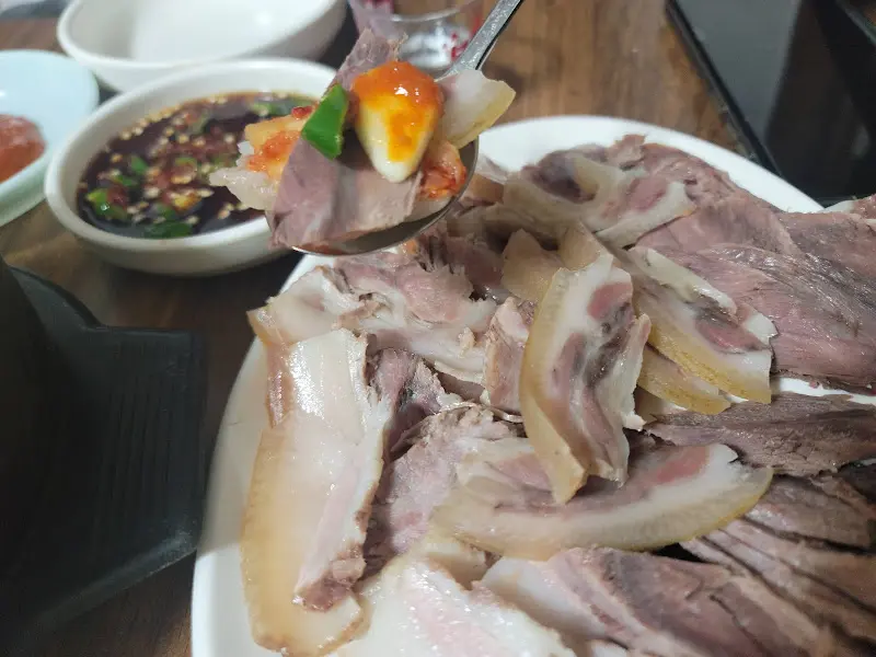 수육을 쌈장에 찍어먹는 모습