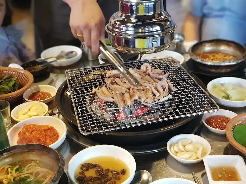 테이블마다 놓인 화로 위 석쇠에 꼼장어가 가득 올려져 있는 모습