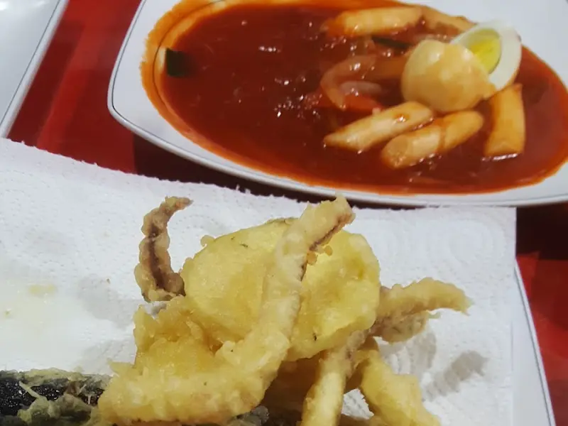 접시 한 켠에 놓인 떡볶이와 오징어 튀김