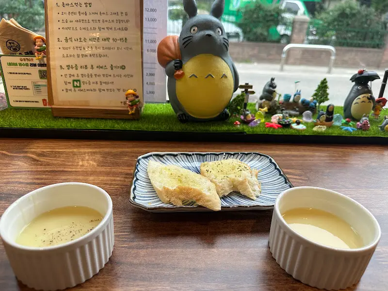 테이블 위에 놓인 토토로 인형과 식전 빵, 스프